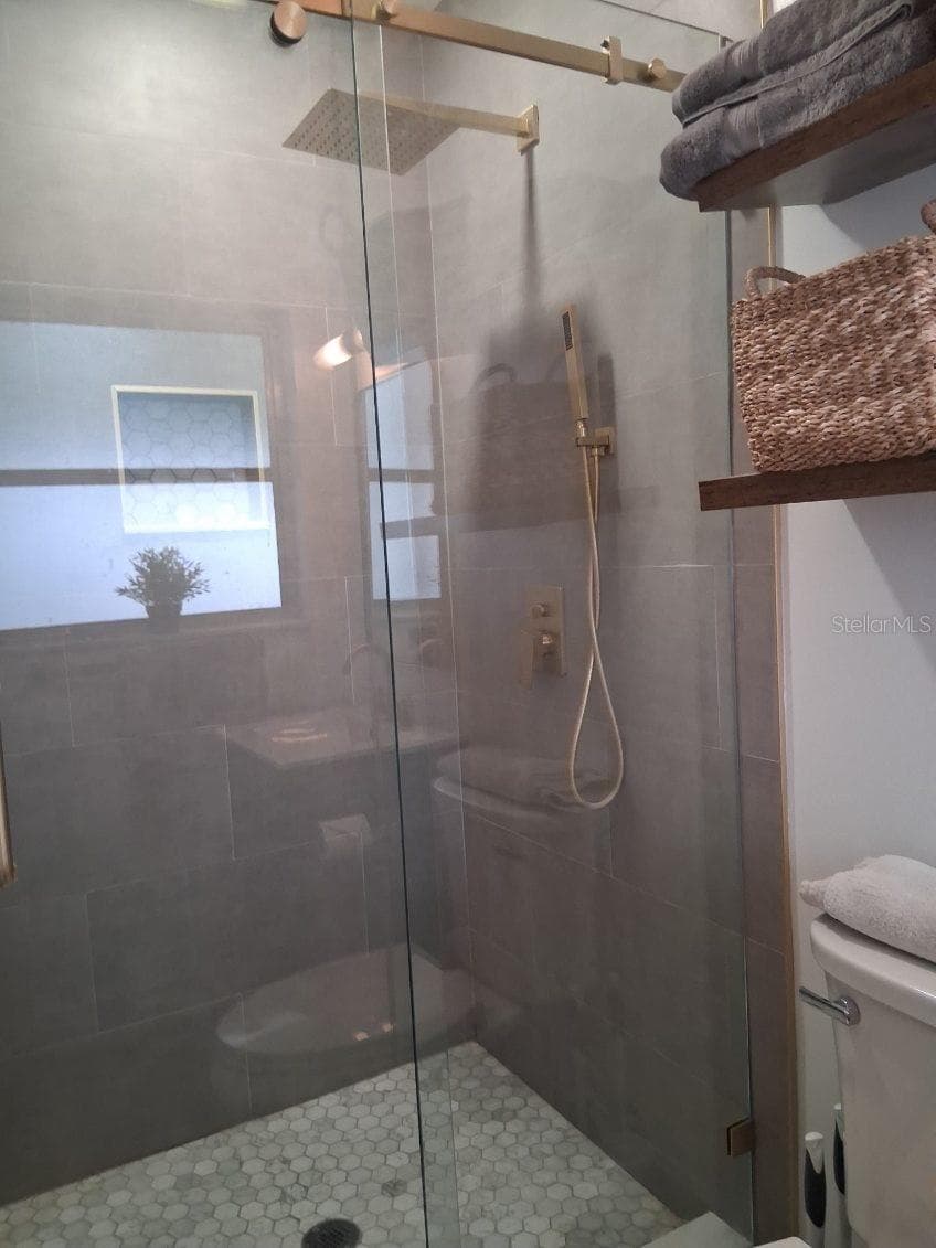 Primary Bath--newly renovated shower with glass door and rainfall showerhead. - 8220 YARDLEY AVE N, ST PETERSBURG
