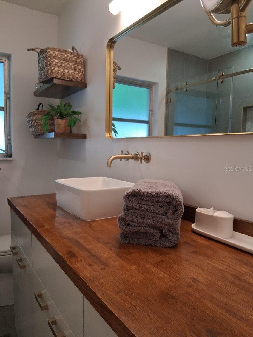 First Floor Guest Bathroom--these cabinets pull out and have custom shelving inside with lots of cubbies for storage - 8220 YARDLEY AVE N, ST PETERSBURG