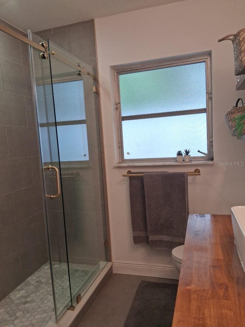 Newly remodeled shower with sliding glass doors - 8220 YARDLEY AVE N, ST PETERSBURG