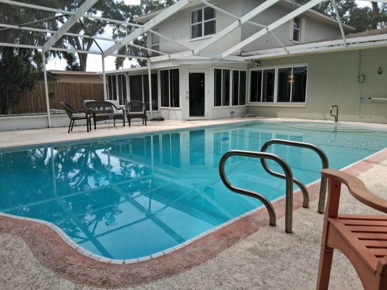 The pool surround is roomy enough for patio furniture, and is fully-screened - 8220 YARDLEY AVE N, ST PETERSBURG