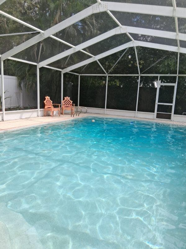 Stairs at the shallow end of the pool for entry/exit, and a ladder at the deep end; screen door goes to pool pump area - 8220 YARDLEY AVE N, ST PETERSBURG