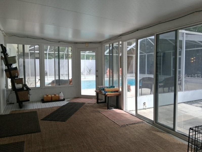 Florida Room has sliders to the backyard and a locked door to the screened pool and surround - 8220 YARDLEY AVE N, ST PETERSBURG