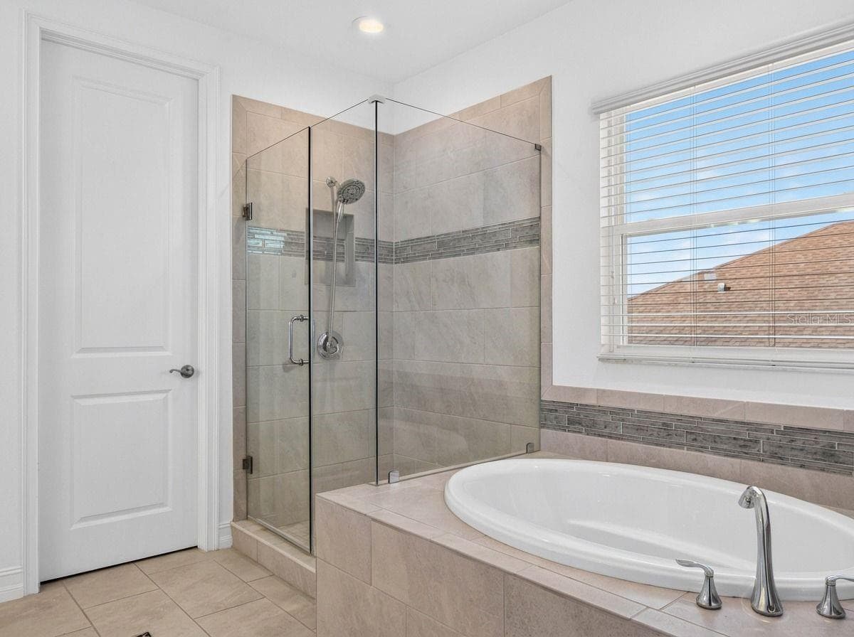 Soaking tub + standing shower in the ensuite to the primary. - 33455 AZALEA RIDGE DR, WESLEY CHAPEL