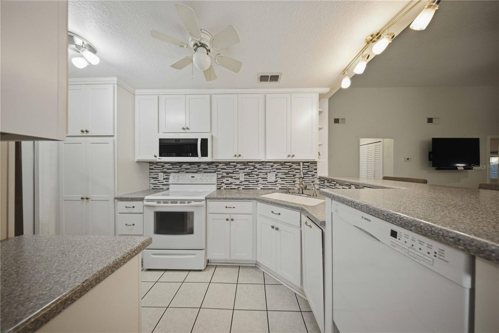 Updated kitchen with raised ceiling, 42" upper cabinets, corian counters, tile backsplash, and on demand instant hot water at sink! - 5013 SE 108TH PL, BELLEVIEW