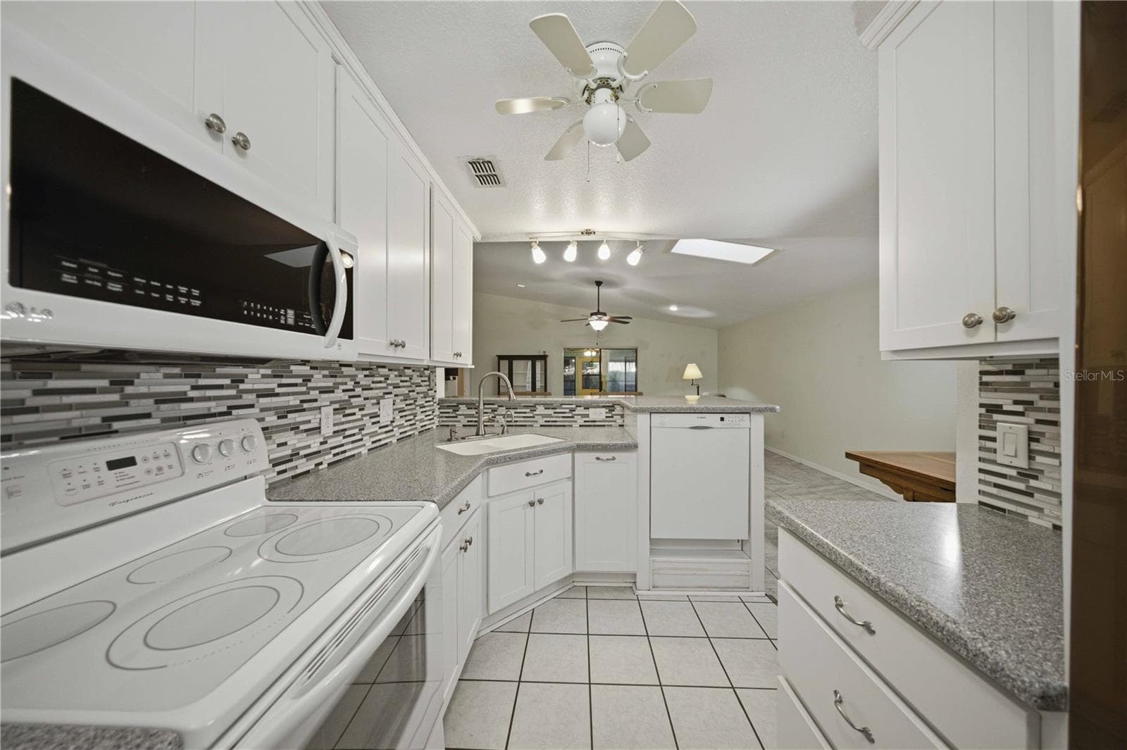View from back of kitchen overlooking the great room, breakfast bar, and dinning area - 5013 SE 108TH PL, BELLEVIEW