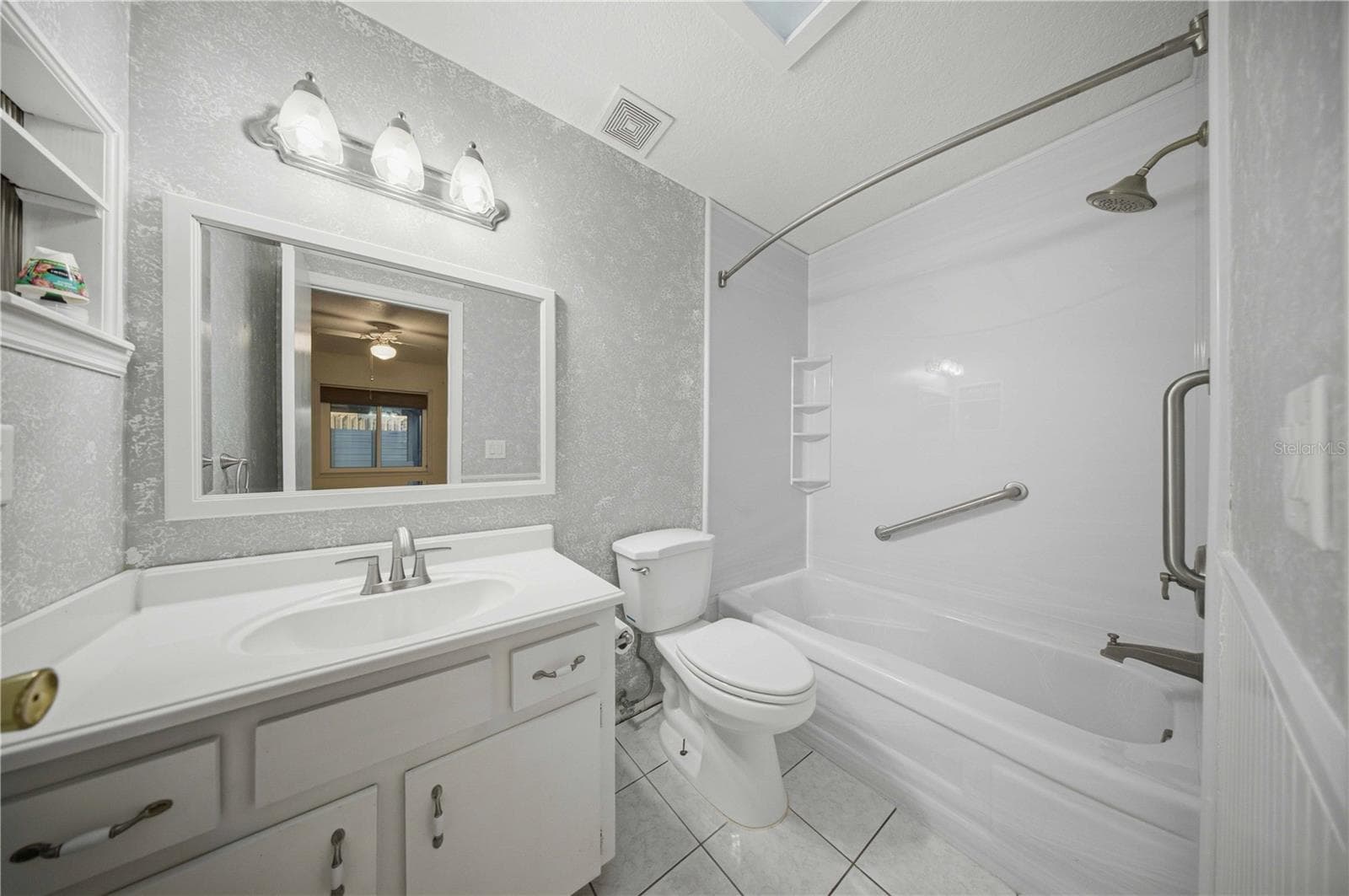 Primary en-suite, with wainscotting, comfort height toilet, and tub/shower combo with grab bars - 5013 SE 108TH PL, BELLEVIEW
