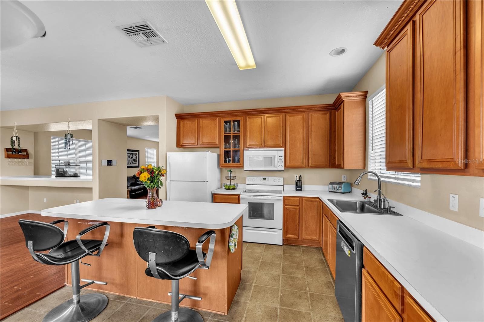The thoughtfully designed kitchen offers an ideal blend of generous counter space, abundant storage, and a functional layout, making meal prep effortless and entertaining a pleasure. - 18801 SUNTERRA DR, LAND O LAKES