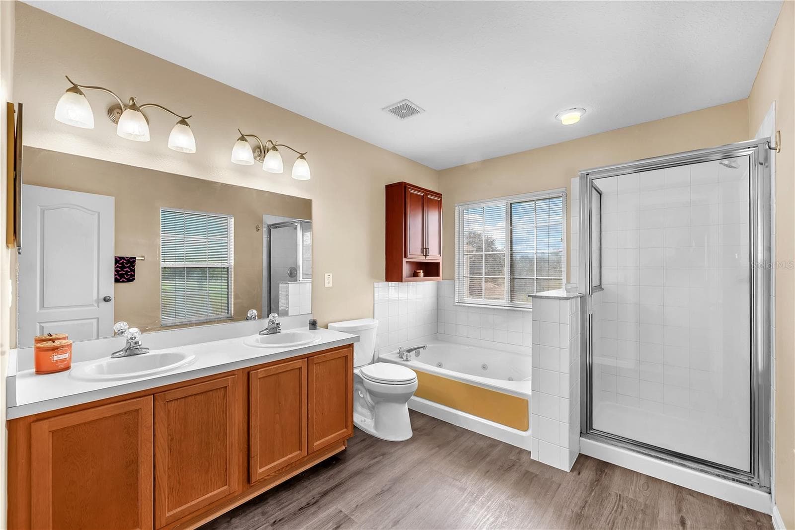 The primary bathroom offers a spa-inspired escape with a relaxing soaking tub, separate shower, and dual-sink vanity. - 18801 SUNTERRA DR, LAND O LAKES