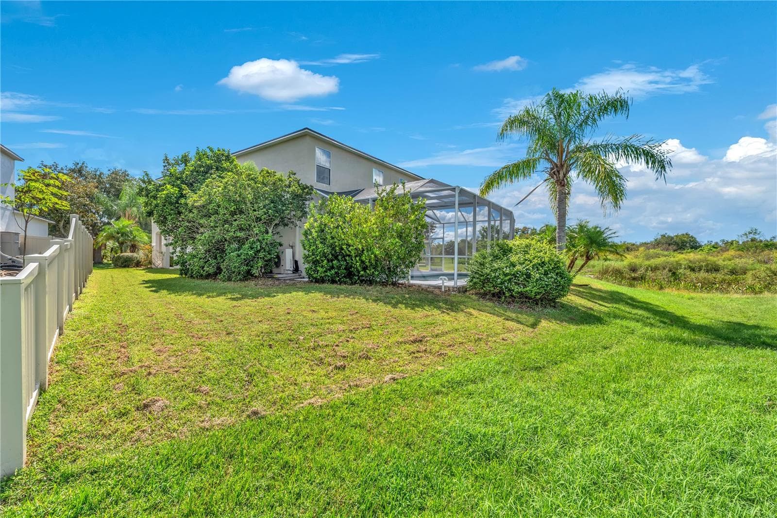 Backyard slopes into conservation area maintained by the HOA. Neighboring home owns vinyl fence. - 18801 SUNTERRA DR, LAND O LAKES