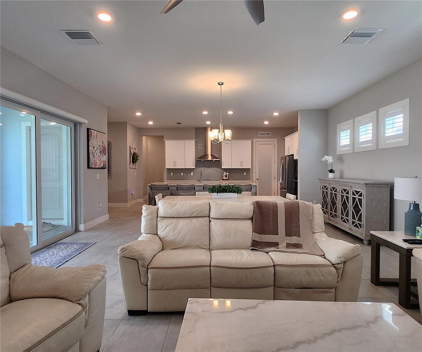 Main home: plantation shutters, remote controlled shade, large living room, dining area, large open kitchen, 3 bedrooms, 2 full bathrooms, 1 guest bathroom, interior laundry room - 8896 DRUMMER PLANK DR, WESLEY CHAPEL