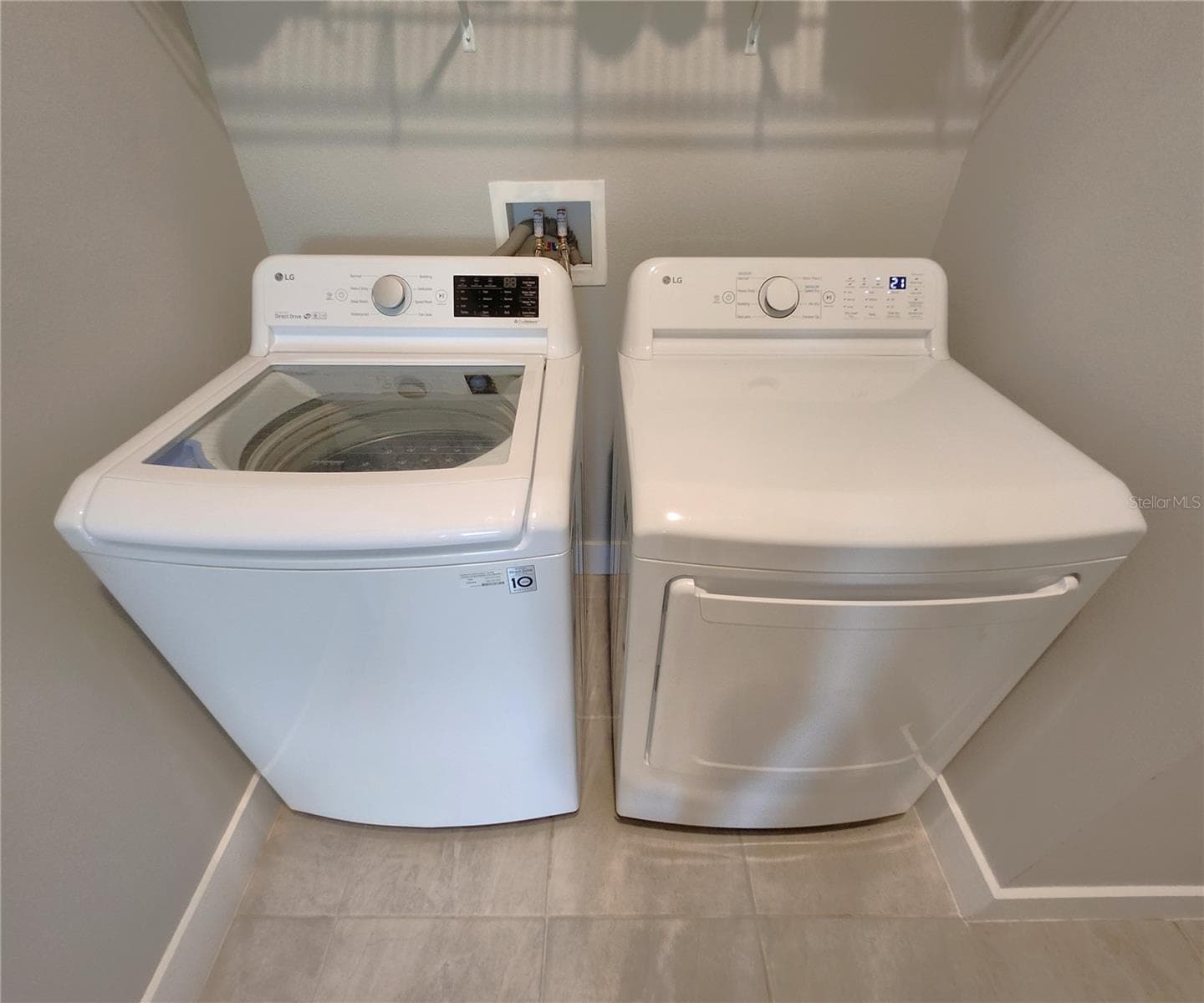 Interior Laundry Room includes side-by-side washer and dryer, ventilated shelves, and storage space - 8896 DRUMMER PLANK DR, WESLEY CHAPEL