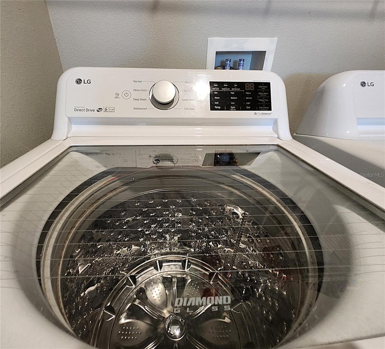 Interior Laundry Room includes side-by-side washer and dryer, ventilated shelves, and storage space - 8896 DRUMMER PLANK DR, WESLEY CHAPEL