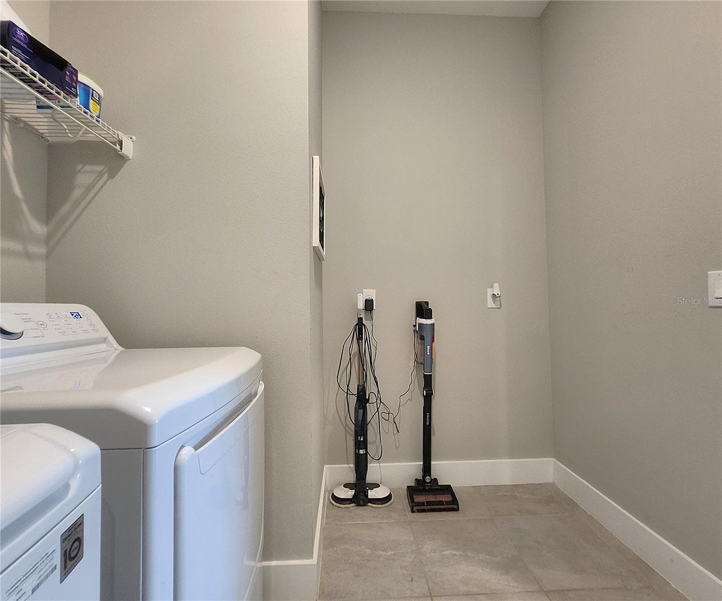 Interior Laundry Room includes side-by-side washer and dryer, ventilated shelves, and storage space - 8896 DRUMMER PLANK DR, WESLEY CHAPEL