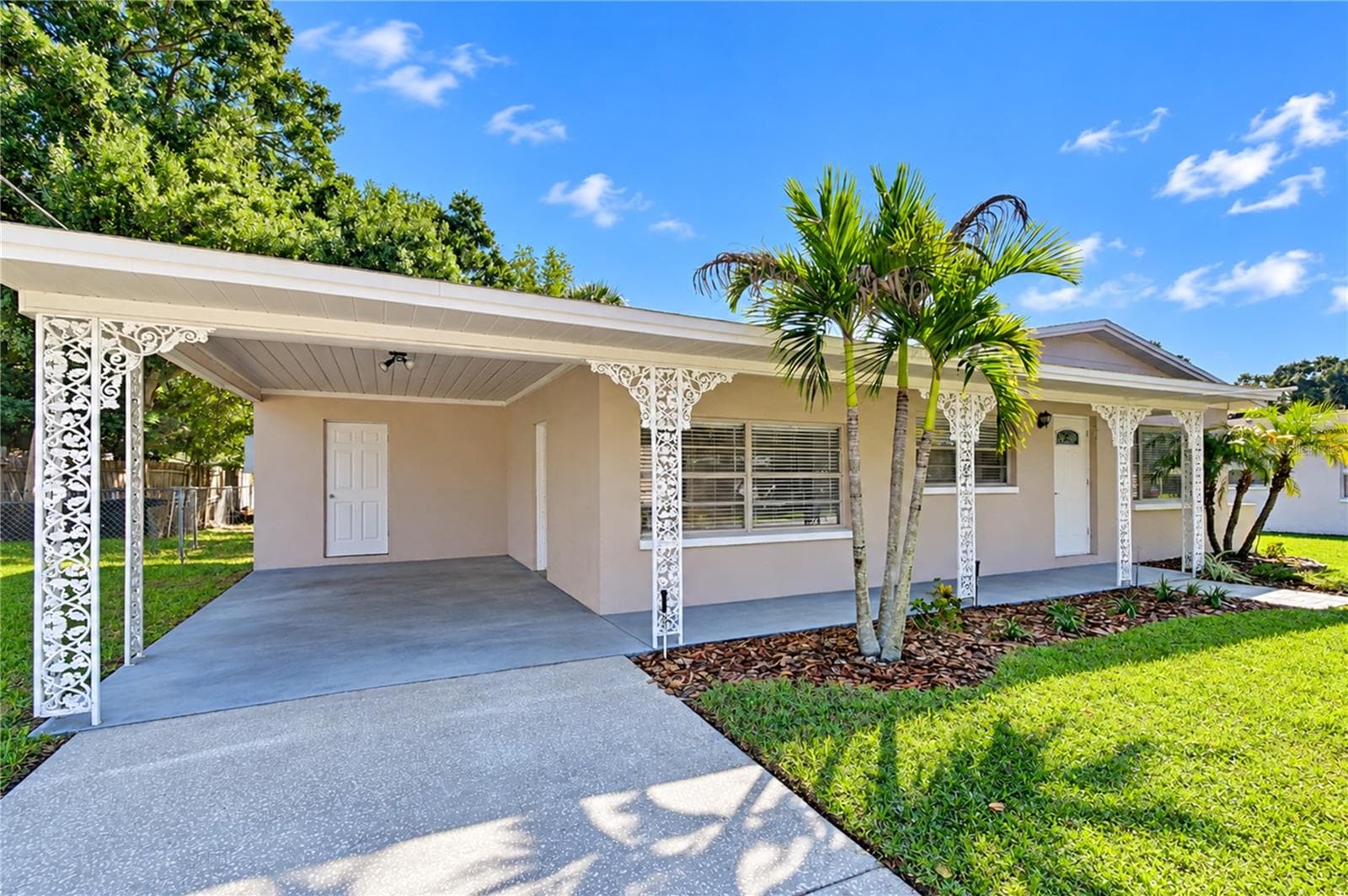 Front exterior view showcasing the well-maintained curb appeal, driveway, and mature landscaping of the property. - 4508 S LOIS AVE, TAMPA