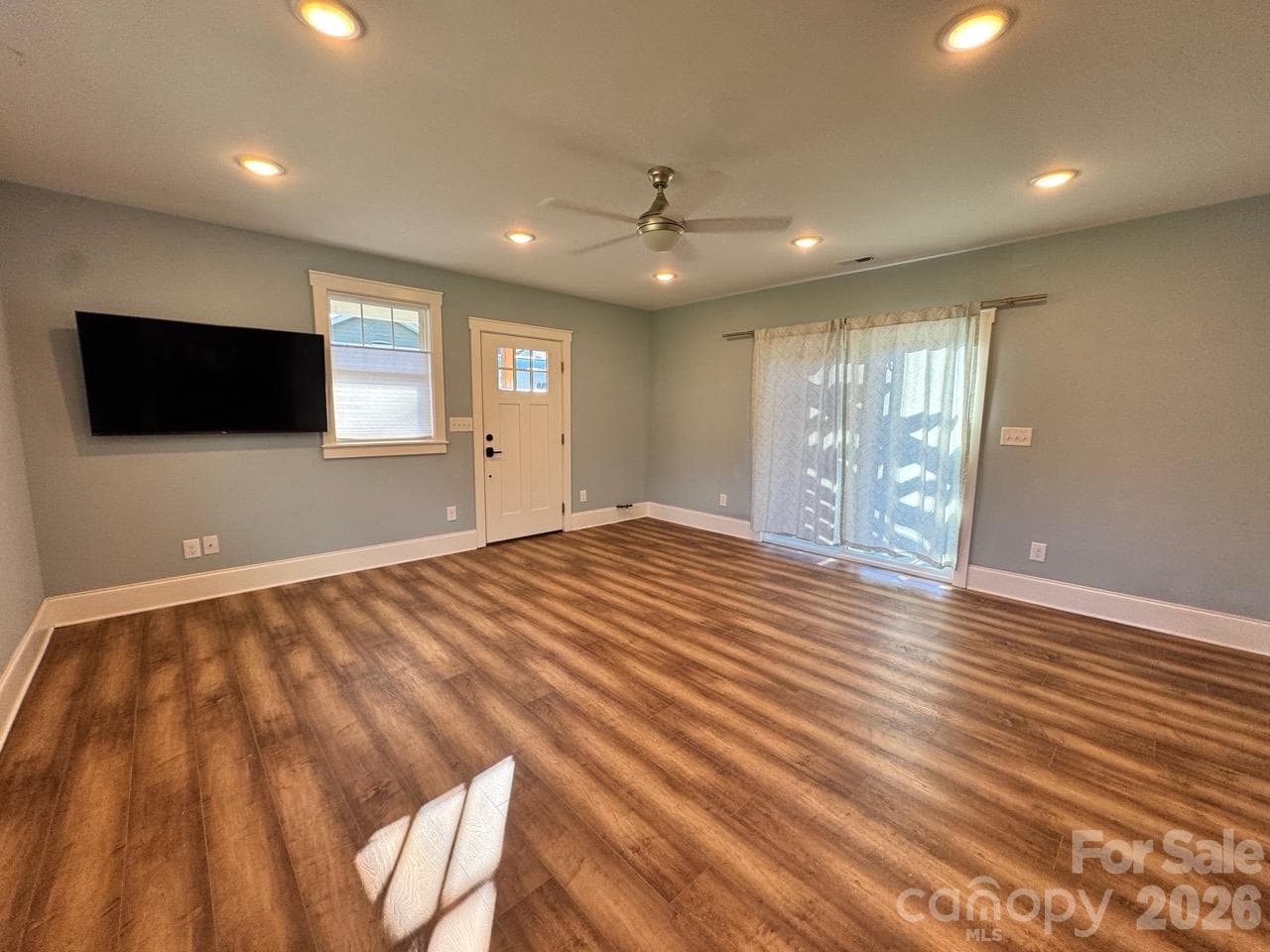 Front entry to living room. Gorgeous LVP flooring throughout except tile in bathroom. Sliding door is to small patio. TV stays!! - 52 North Lane, Brevard