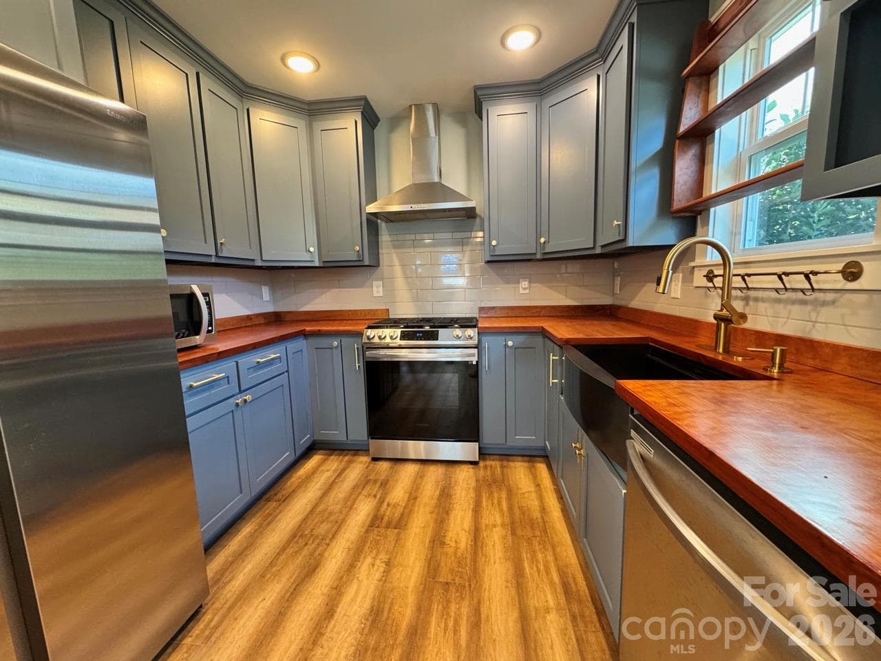 Sleek kitchen with SS appliances, cherry wood countertops, tile backsplash and farm sink. Notice the propane gas range!!! - 52 North Lane, Brevard