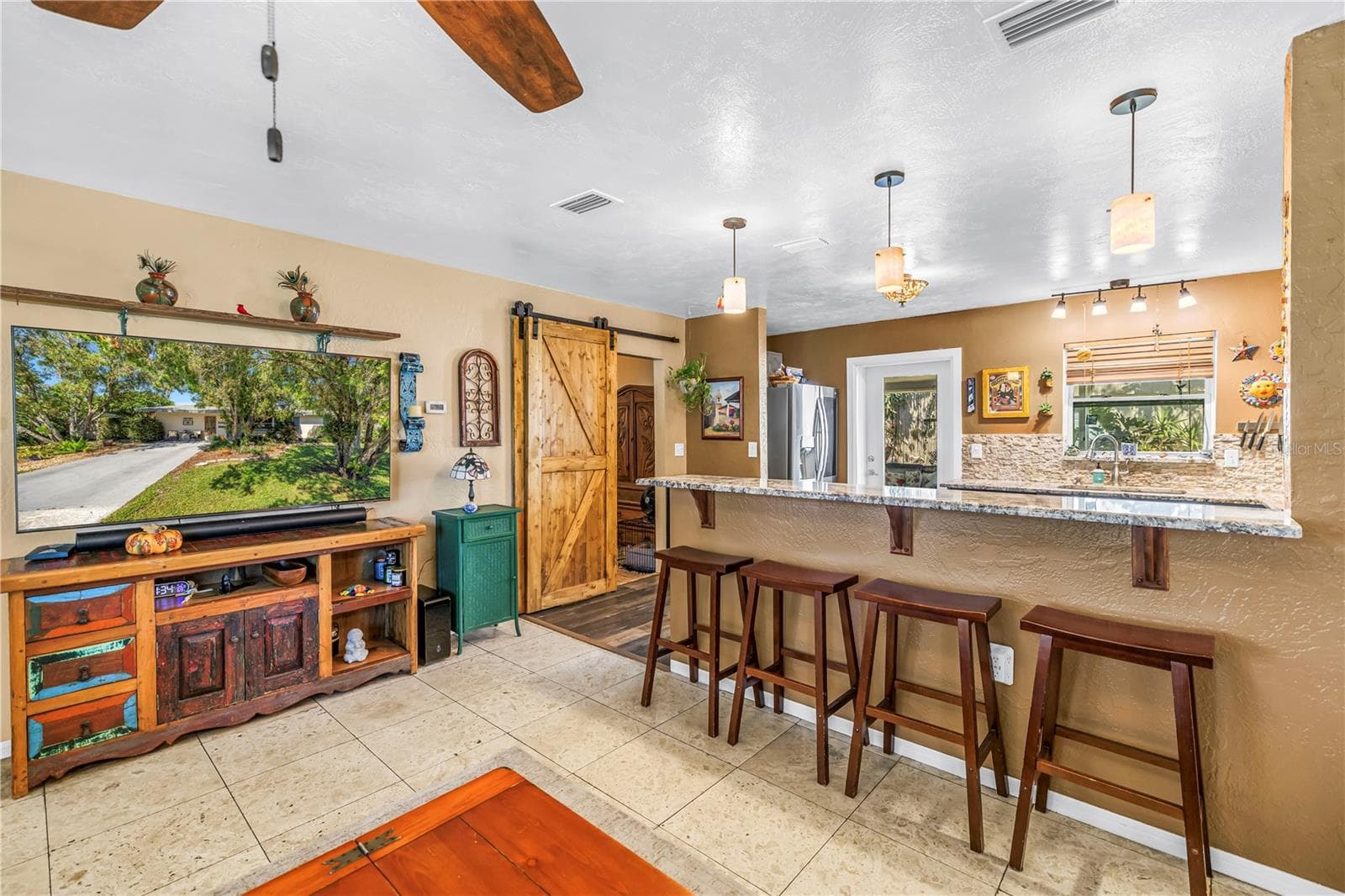 Breakfast bar seating at the kitchen and barn door is to the primary bedroom. - 2573 62ND TER N, ST PETERSBURG