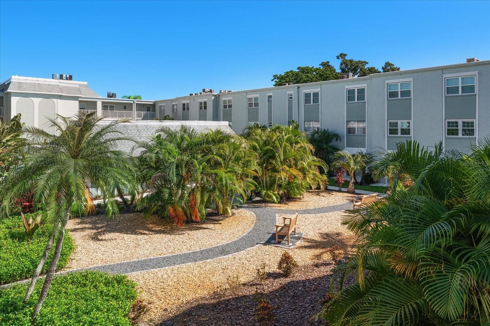 Courtyard with lush tropical landscaping - 1706 BELLEAIR FOREST DR #238, BELLEAIR