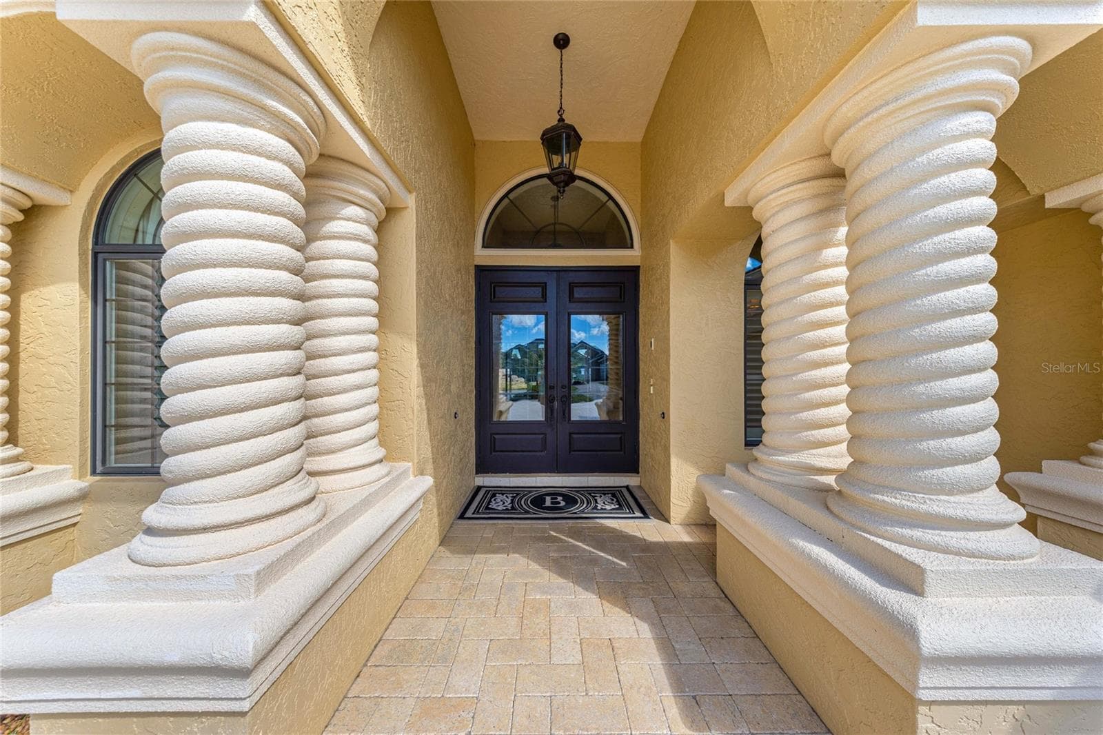 Impressive covered entryway featuring distinctive spiral columns, decorative arches, elegant double doors, and beautiful paver flooring. - 6501 SW 179TH AVENUE RD, DUNNELLON