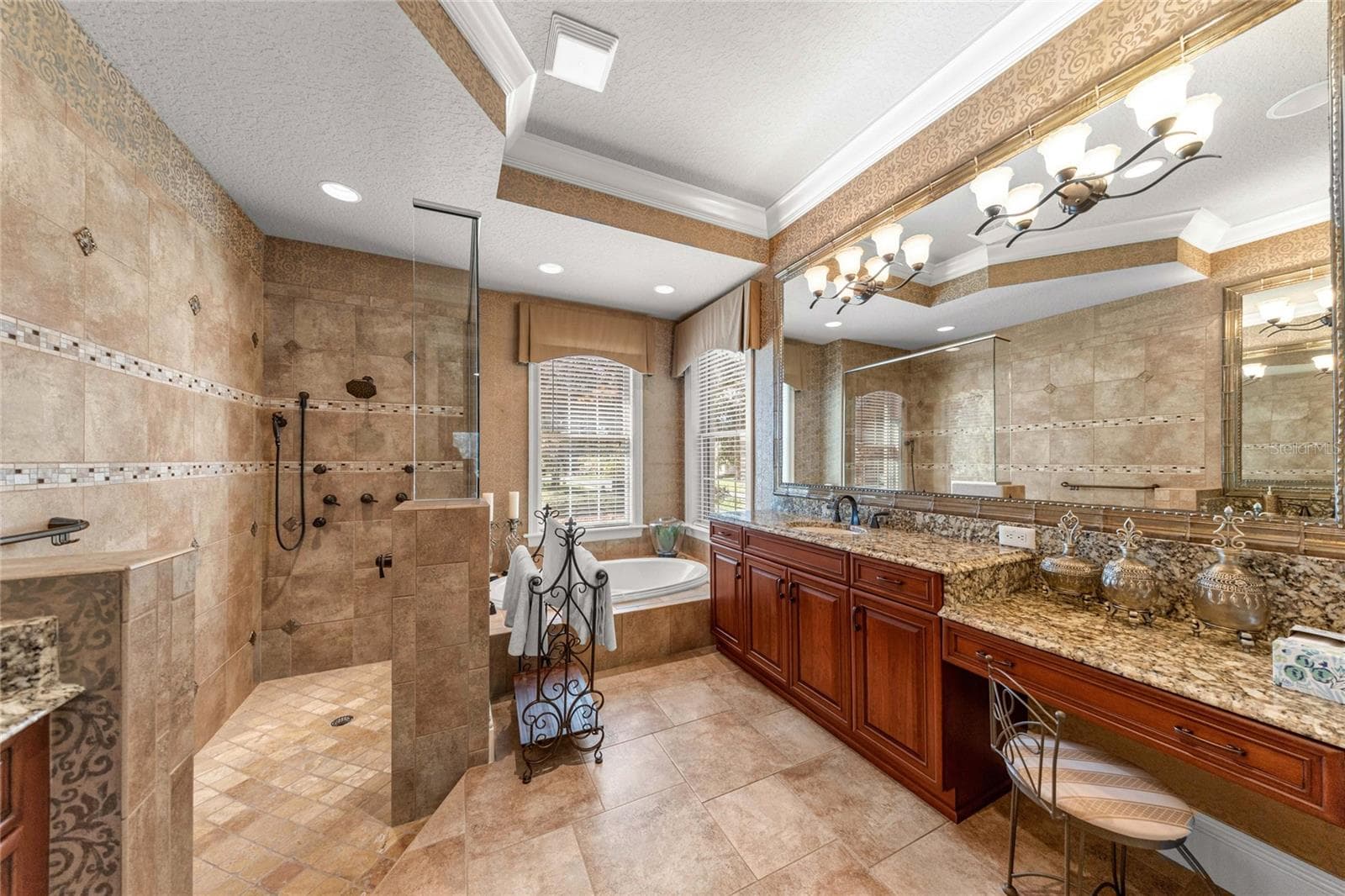 Luxurious owner's bathroom with granite countertops, custom cabinetry, spacious walk-in shower, and soaking tub. - 6501 SW 179TH AVENUE RD, DUNNELLON