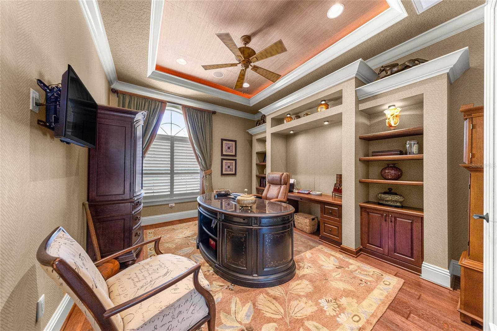 Elegant private office with double-door entry, custom shelving, built-in workspace, and decorative ceiling lighting. - 6501 SW 179TH AVENUE RD, DUNNELLON