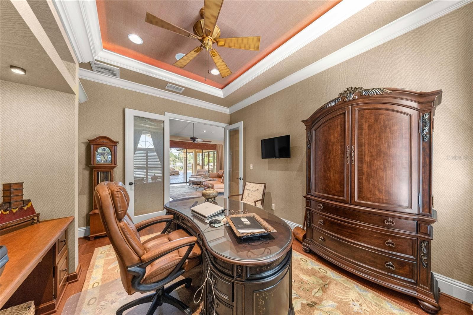 Private office or media room featuring a stunning illuminated tray ceiling, custom built-ins, and rich wood flooring. - 6501 SW 179TH AVENUE RD, DUNNELLON