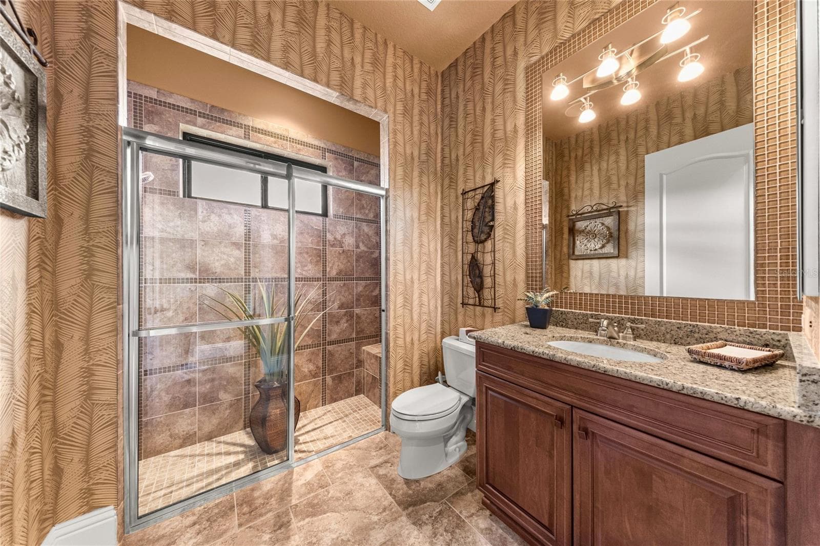 Attractive bathroom featuring granite countertops, wood cabinetry, decorative wall finishes, and natural light. - 6501 SW 179TH AVENUE RD, DUNNELLON