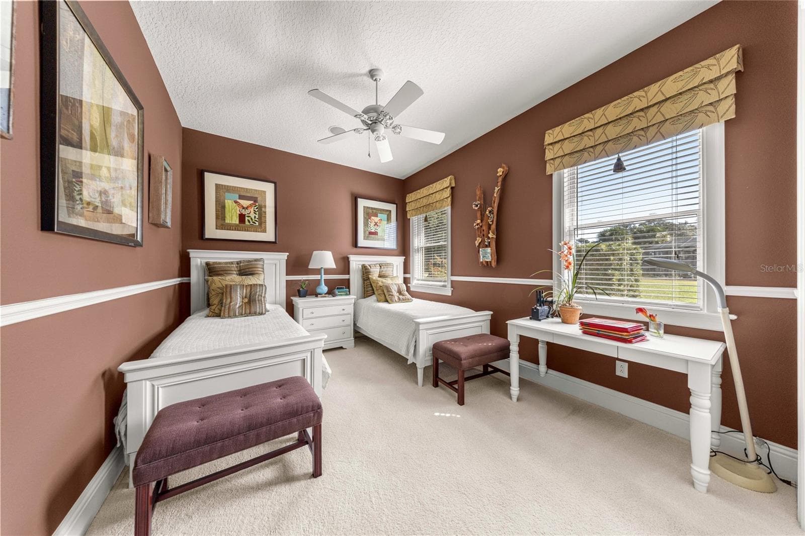 Spacious bedroom featuring two windows, ceiling fan, generous closet space, and room for a desk or study area. - 6501 SW 179TH AVENUE RD, DUNNELLON