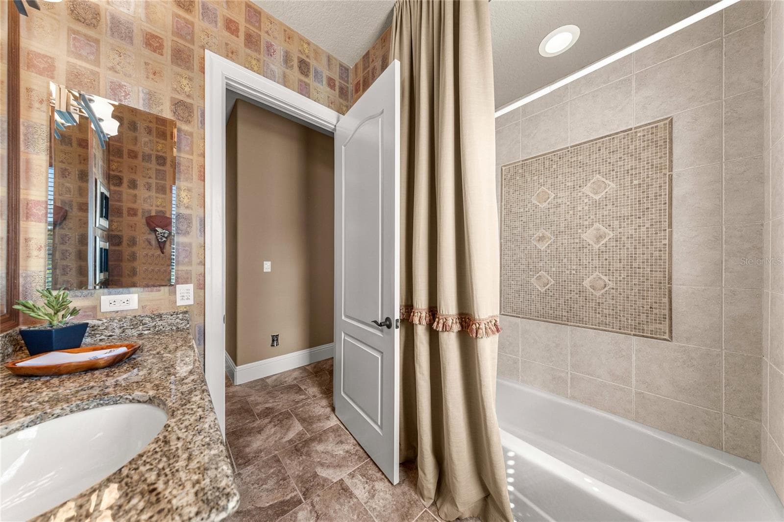 Tub and shower combination with decorative tile surround and accent detailing, offering both style and functionality. - 6501 SW 179TH AVENUE RD, DUNNELLON