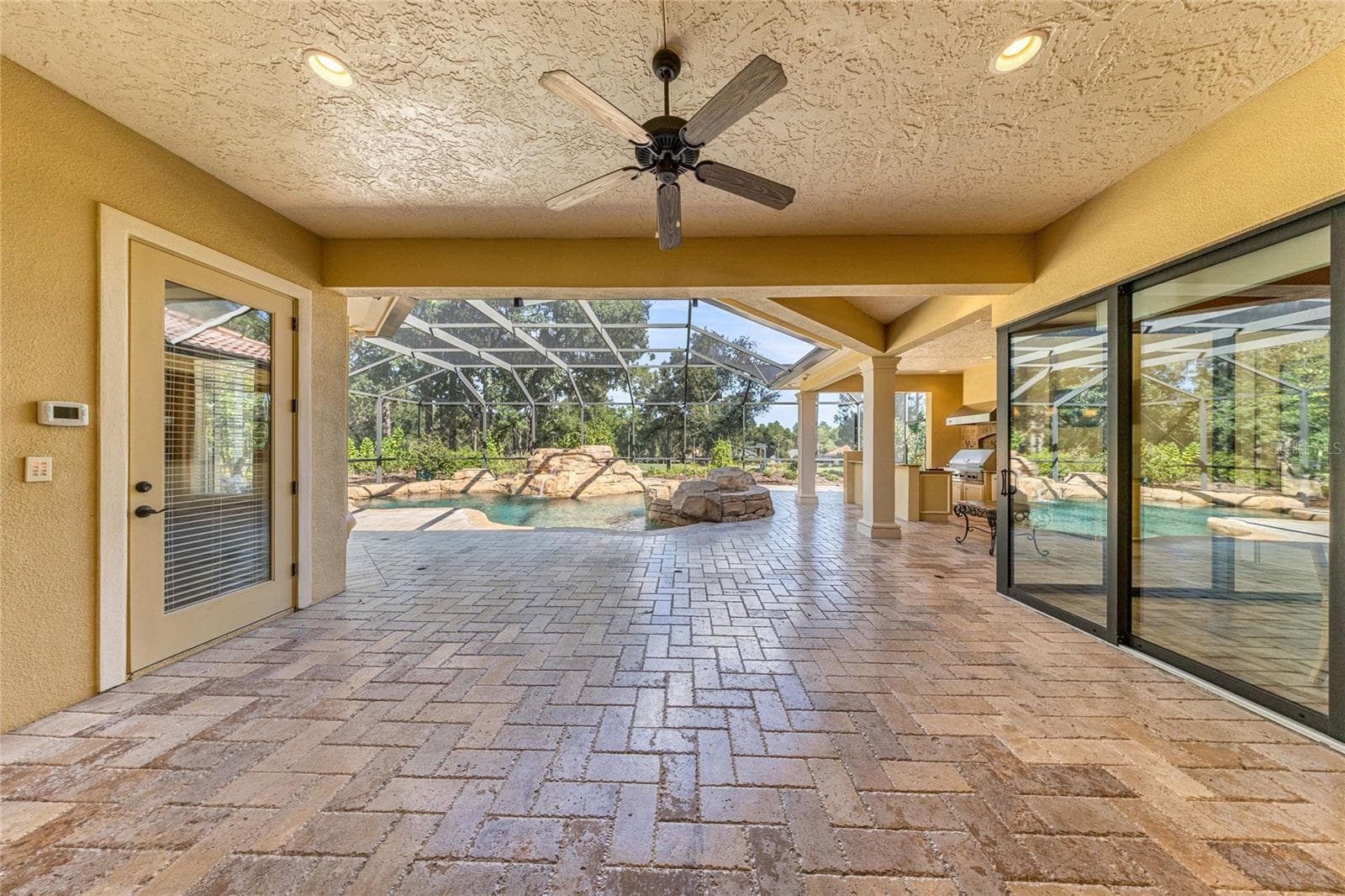 Oversized covered outdoor living area with fully opening sliding glass doors connecting to the main living space. - 6501 SW 179TH AVENUE RD, DUNNELLON