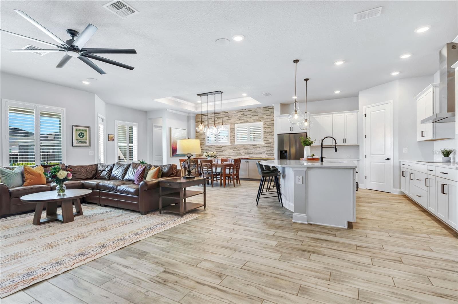 Bright great room open to the kitchen with high ceilings, ceiling fan, and plantation shutters. Easy everyday living in Laureate Park, Lake Nona. - 8336 CANETTI ST, ORLANDO