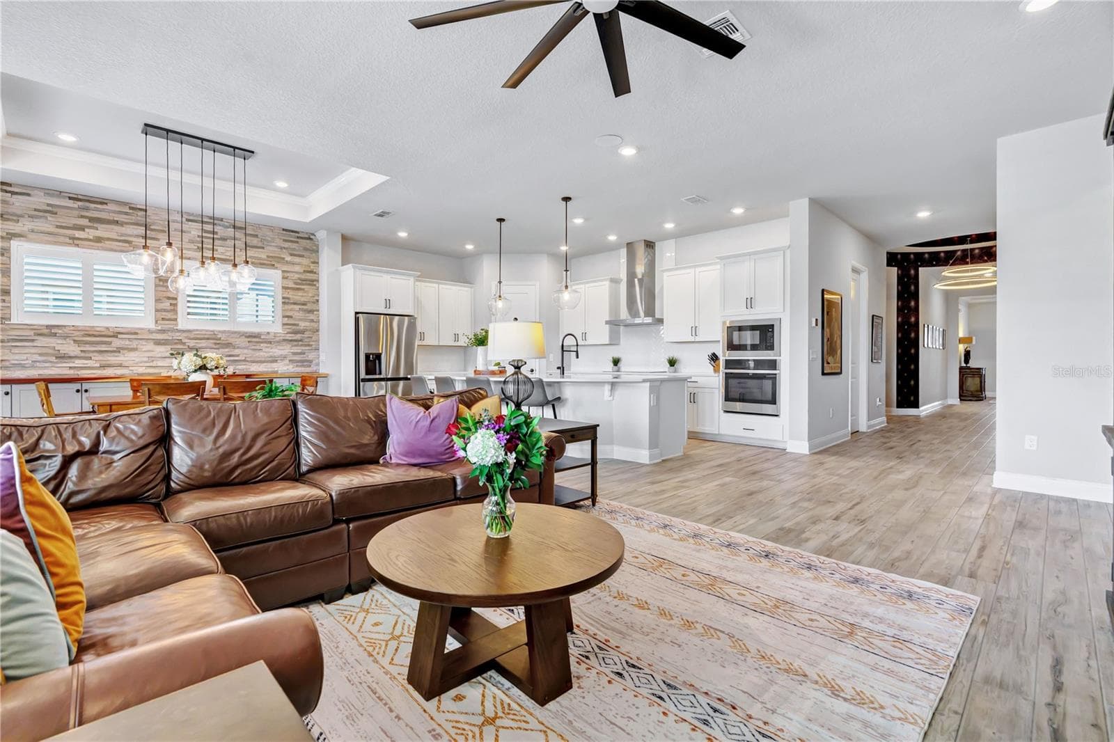 Living area designed for gathering, open to the kitchen and dining space. A natural flow for entertaining in this Orlando 32827 home. - 8336 CANETTI ST, ORLANDO