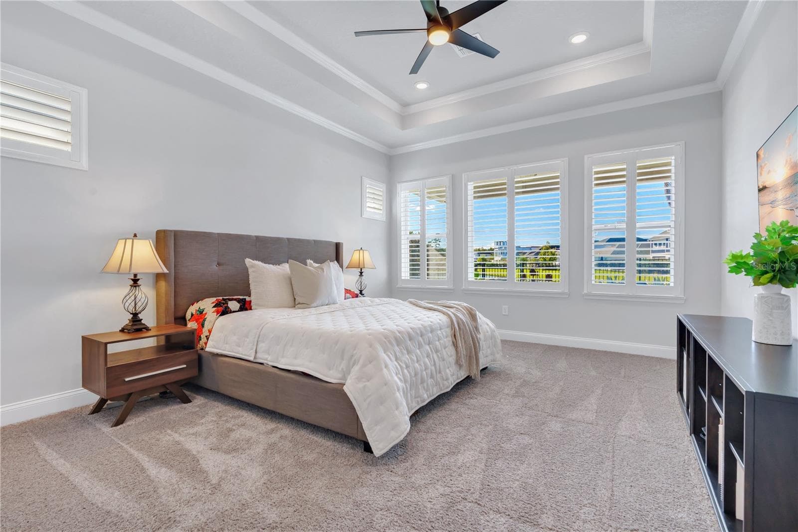 Primary bedroom with a tray ceiling and plenty of natural light, privately positioned in the split bedroom floor plan. - 8336 CANETTI ST, ORLANDO