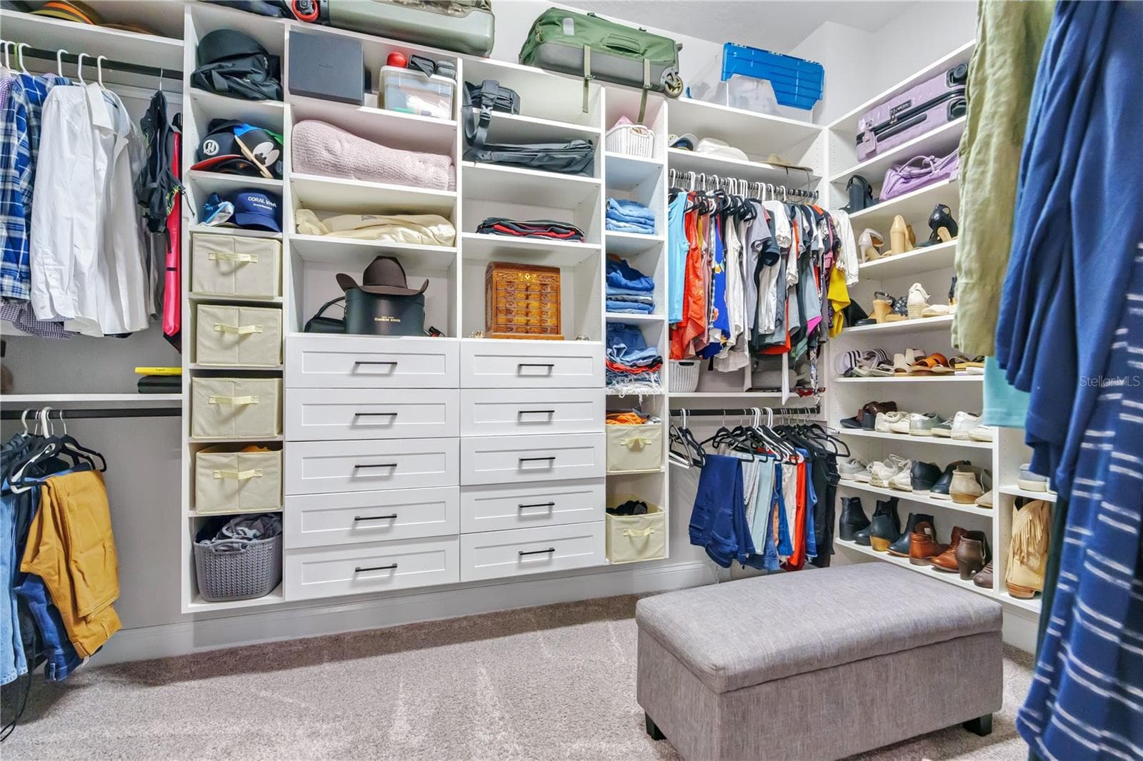 Oversized primary walk in closet with custom built ins, shelving, and drawers for organized storage. - 8336 CANETTI ST, ORLANDO