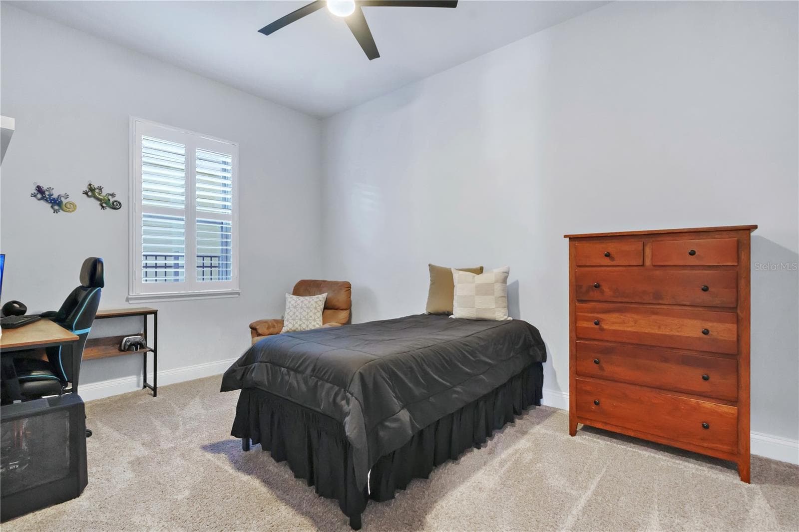Secondary bedroom with ceiling fan, carpet, and a built in closet system. - 8336 CANETTI ST, ORLANDO