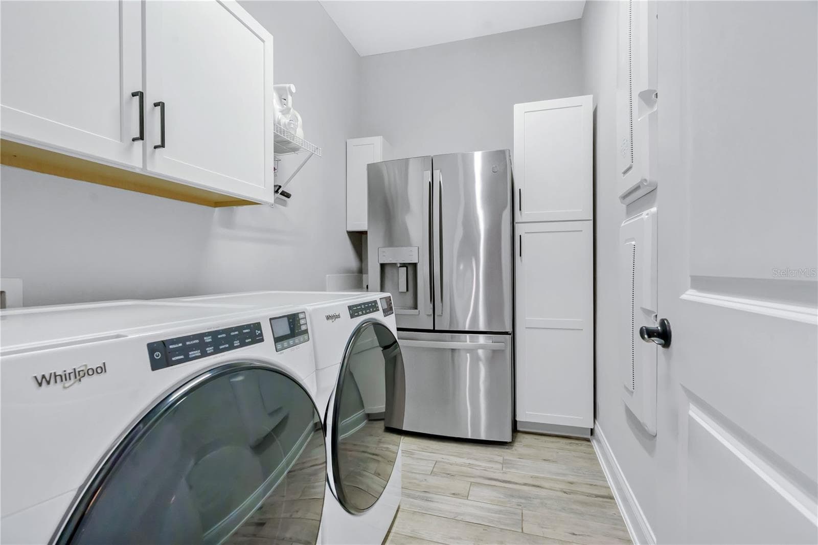 Laundry room with storage cabinetry and space for a second refrigerator, plus a mud room drop zone near the entry. - 8336 CANETTI ST, ORLANDO