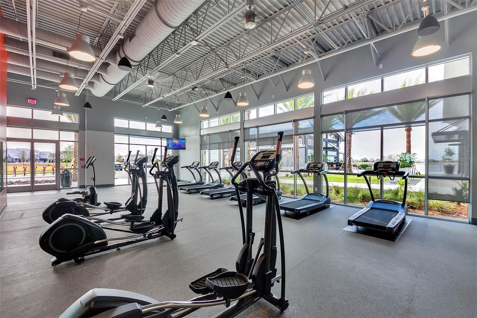 Bright community fitness center with cardio equipment and floor to ceiling windows in Laureate Park, Lake Nona. - 8336 CANETTI ST, ORLANDO
