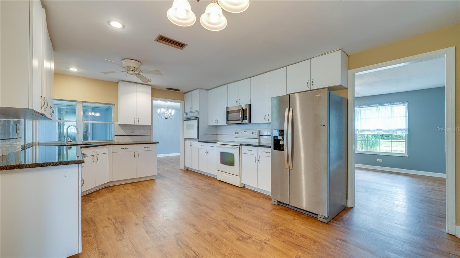 Spacious kitchen featuring LVT flooring. - 909 SE 27TH ST, CAPE CORAL