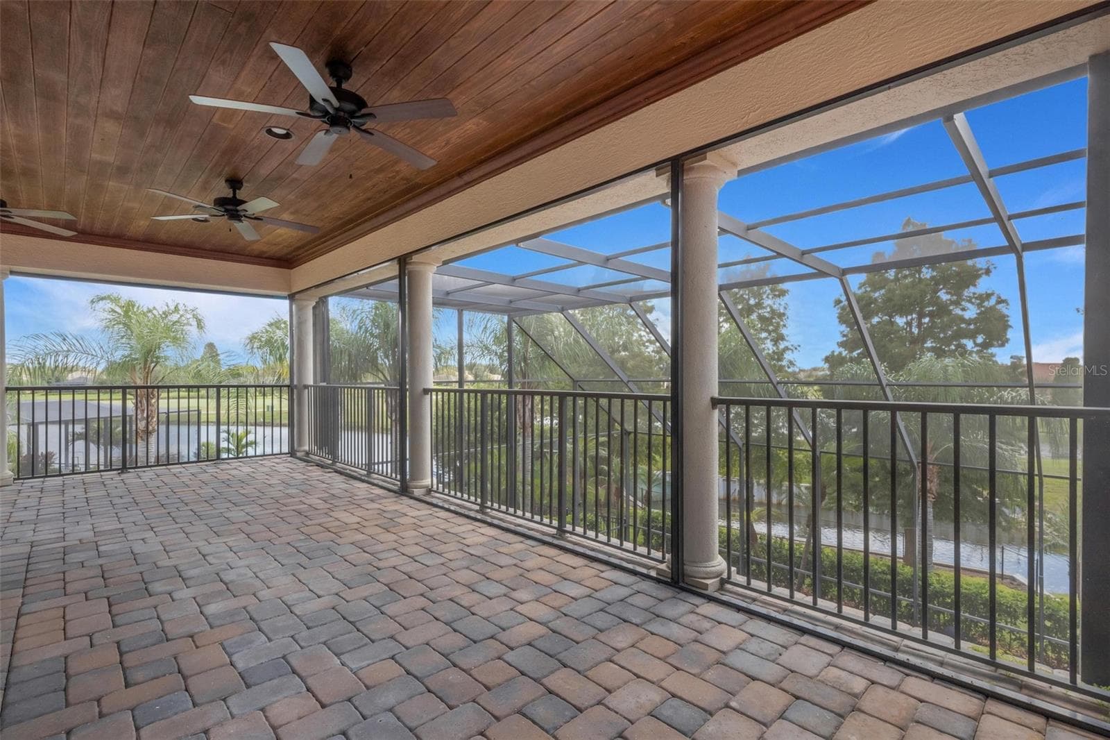 The large screen enclosed balcony overlooks the pool below and the golf course and waterways beyond. - 2734 BELLERIVE DR, LAKELAND