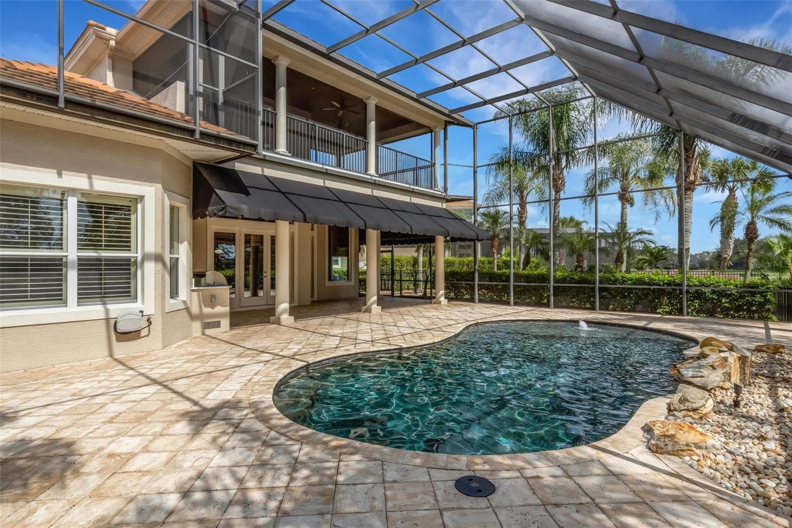 Lagoon inspired pool complete with beach area and rock water feature. - 2734 BELLERIVE DR, LAKELAND