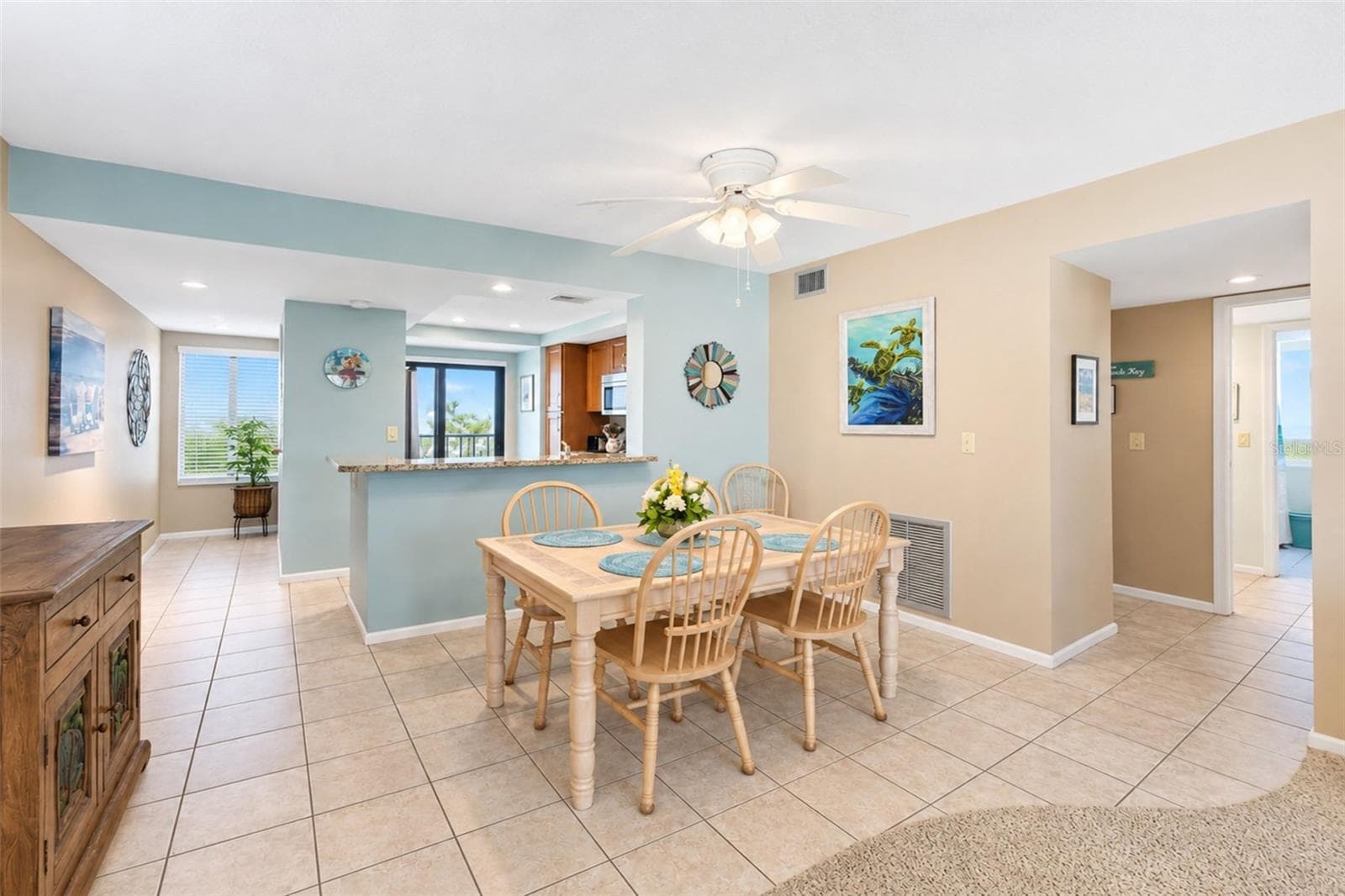 The dining room has tiled flooring and a ceiling fan with light. - 2950 N BEACH RD #A321, ENGLEWOOD