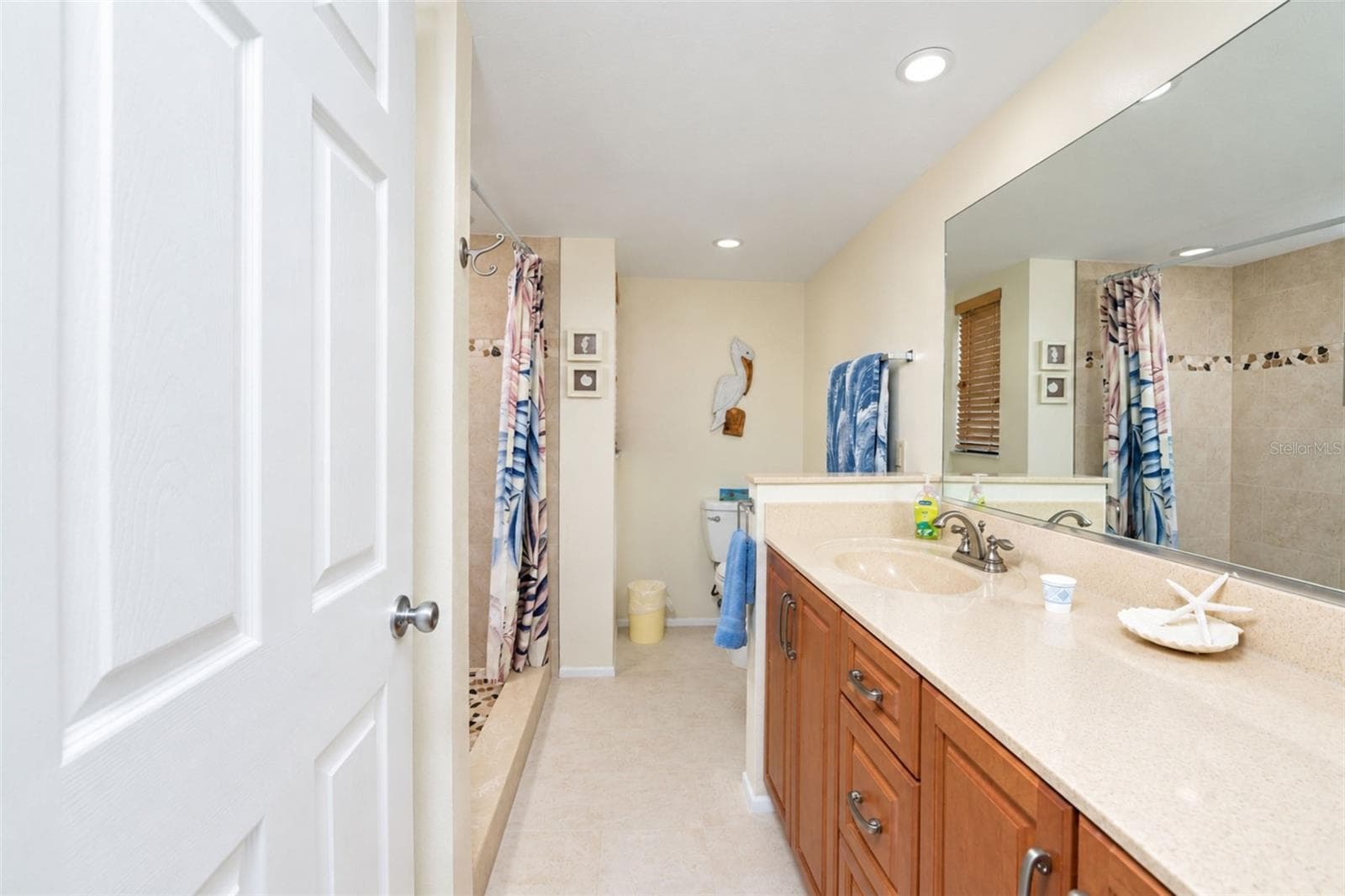 The primary bathroom has a solid surface countertop vanity with plenty of storage and tiled flooring. - 2950 N BEACH RD #A321, ENGLEWOOD