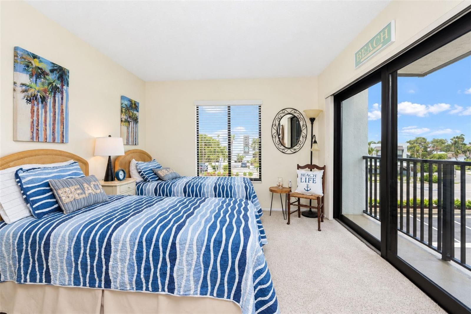 The guest bedroom has carpeted flooring and impact sliding glass doors to the French balcony. - 2950 N BEACH RD #A321, ENGLEWOOD