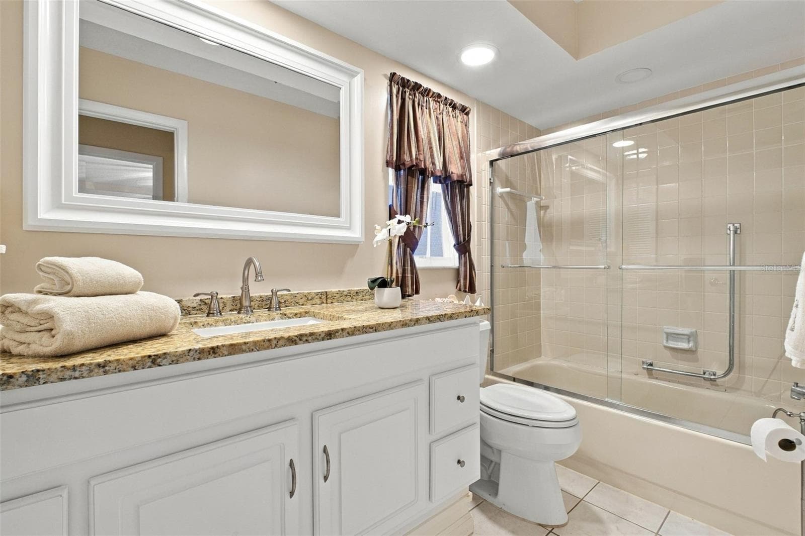 Beautifully updated hall bath with newer oversized vanity with stone top, mirror, recessed lighting, and tub/shower combo~ - 1743 MACDONNELL DR, PALM HARBOR