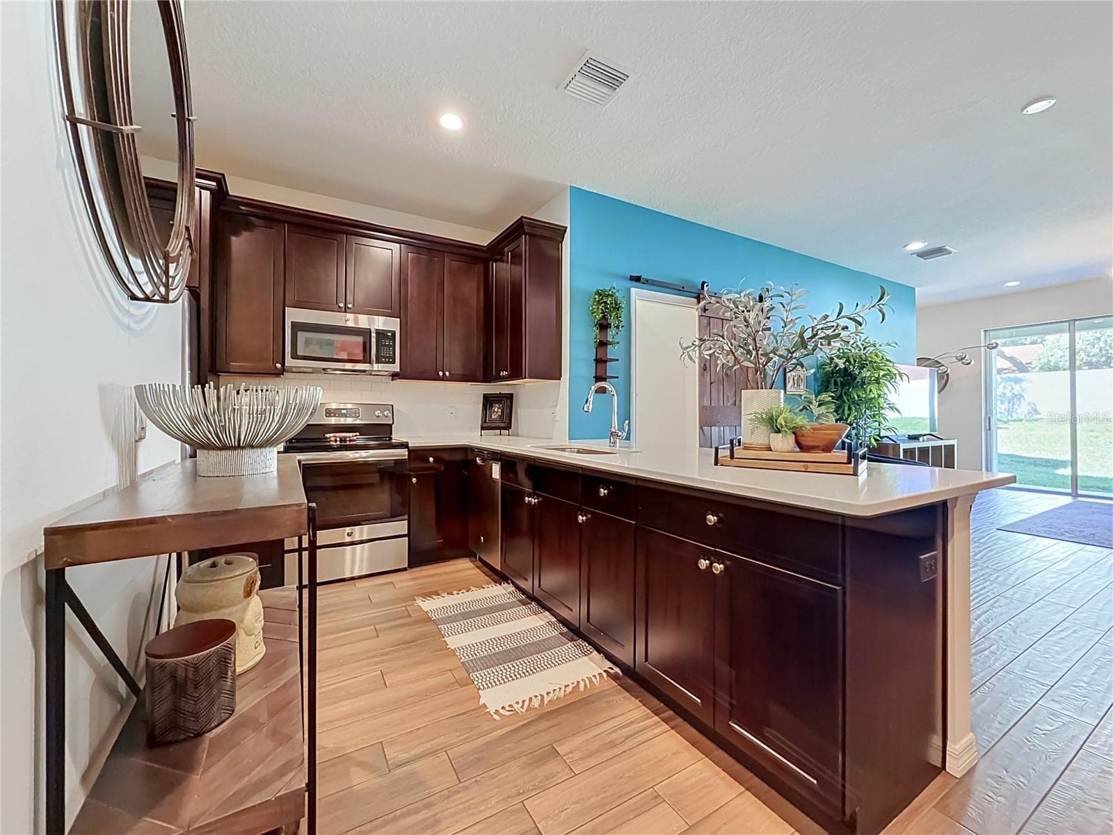 The well-appointed kitchen offers SOLID WOOD CABINETRY, GRANITE countertops, stainless steel appliances, a breakfast bar, and ample storage. - 2270 MONTVIEW DR, CLEARWATER