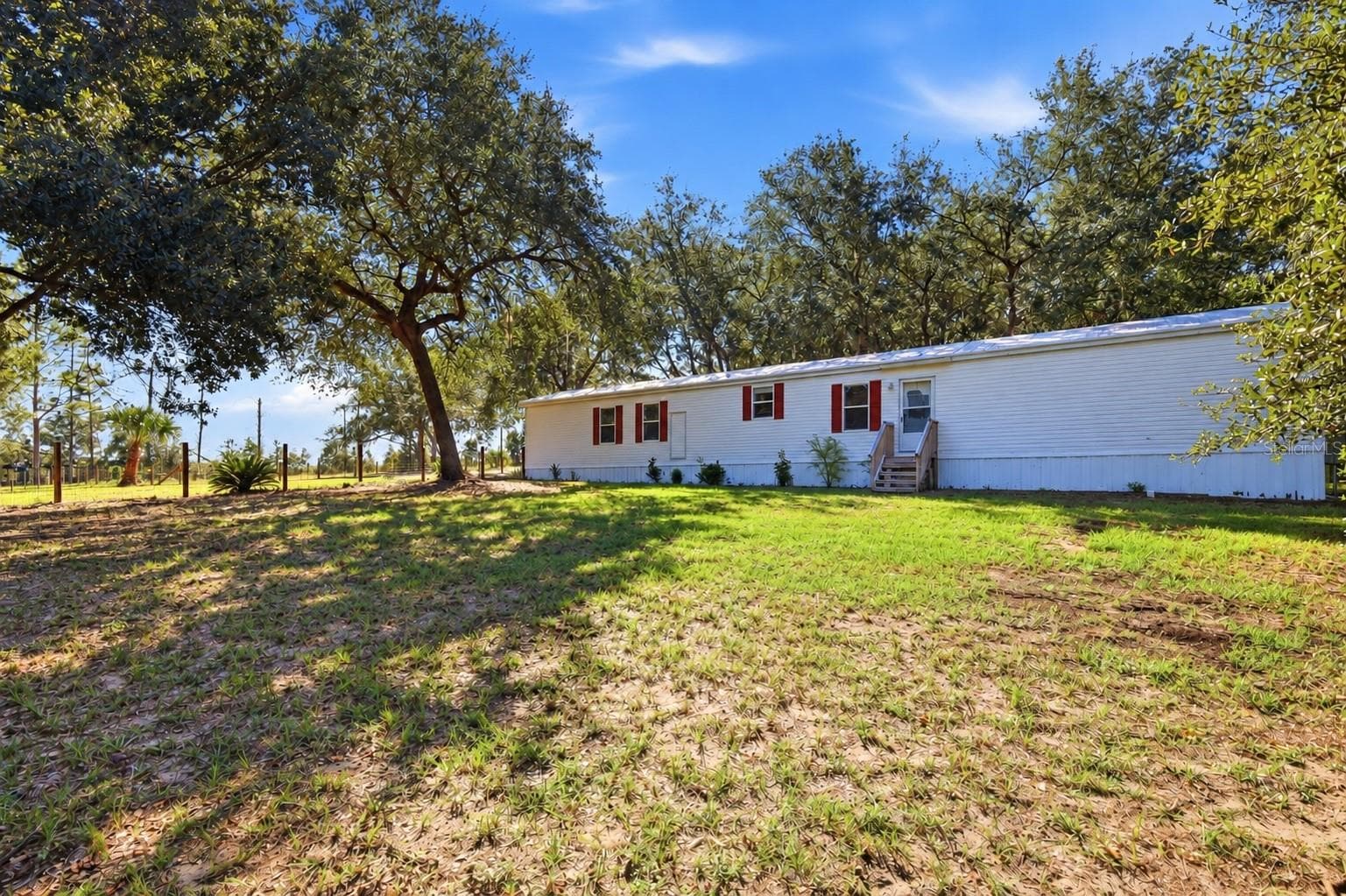 Front of home with 1 of 3 large fenced in area - 2138 LAKE ELLA RD, FRUITLAND PARK
