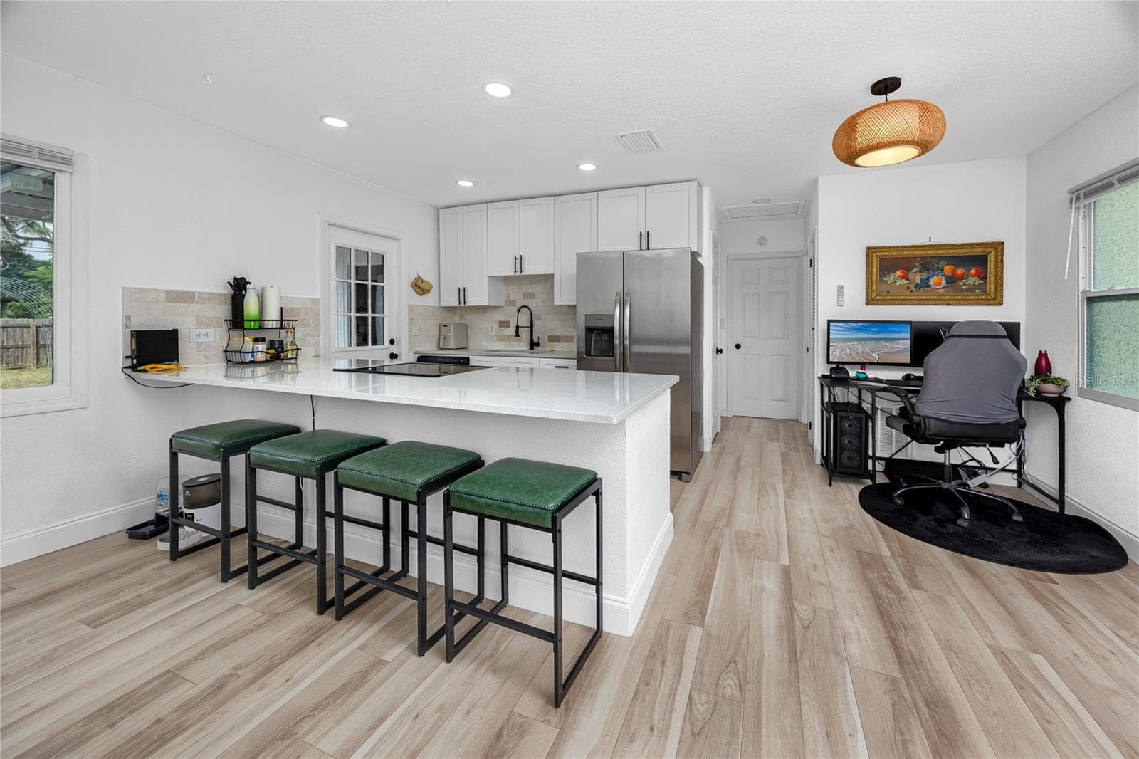 View of the kitchen with breakfast bar and dining room. - 5735 BURLINGTON AVE N, ST PETERSBURG