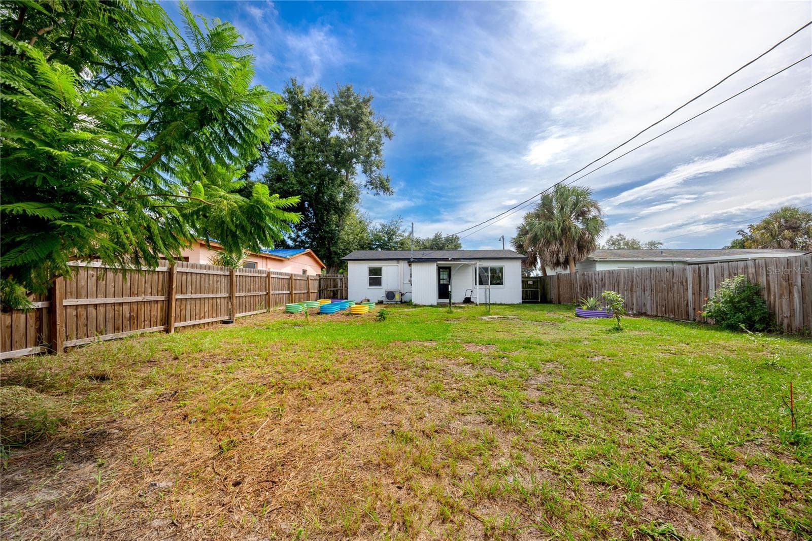 View of the rear of the house with backyard - 5735 BURLINGTON AVE N, ST PETERSBURG