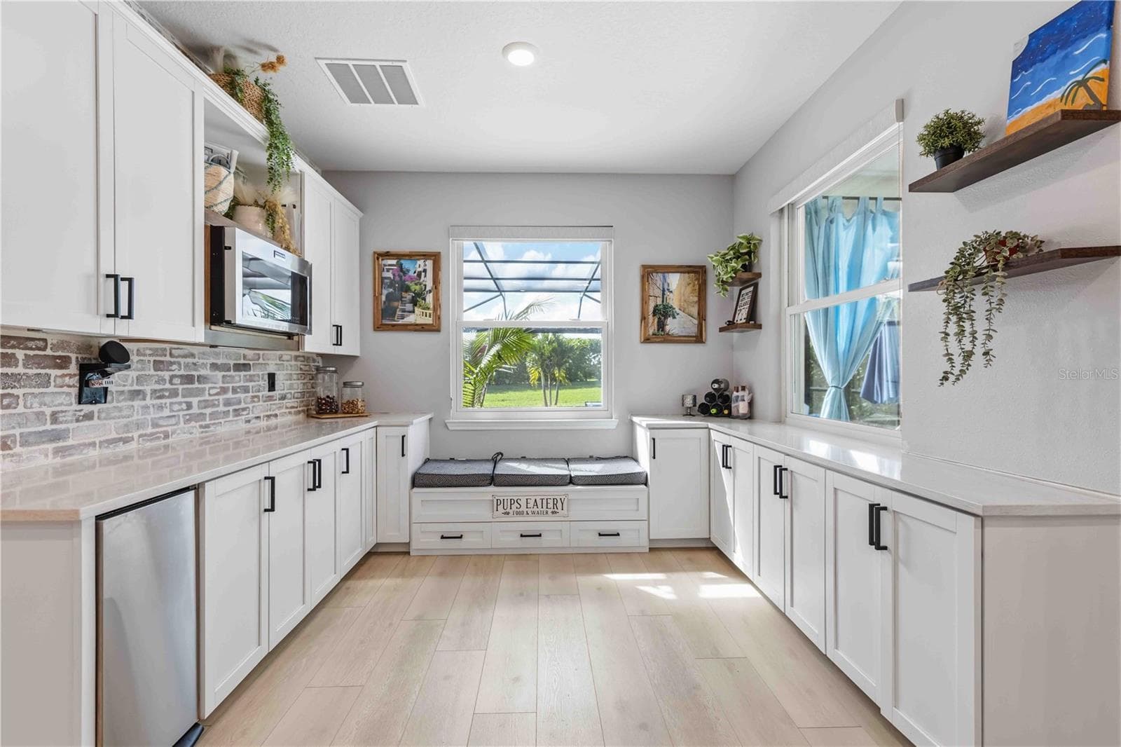 extended kitchen featuring trash compactor, built-in cubbies/seating & microwave - 17604 BARLEY DR, LAKEWOOD RANCH