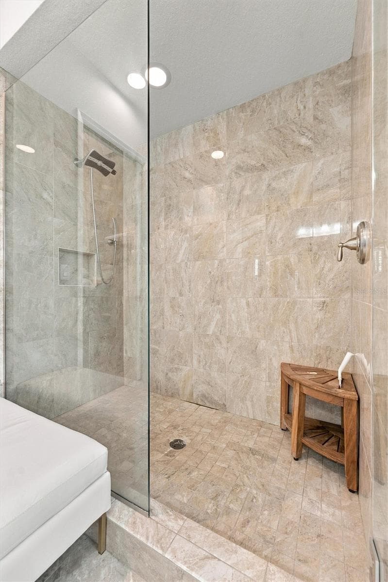 The spacious primary ensuite features dual vanities, a large walk-in shower, a private water closet, and convenient access to one of the suite’s two walk-in closets. - 291 COMPASS POINT DR #201, BRADENTON